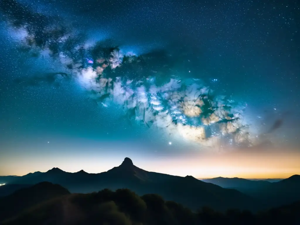 La majestuosa Vía Láctea destaca en el cielo estrellado sobre el perfil montañoso, con luces de ciudad en el horizonte