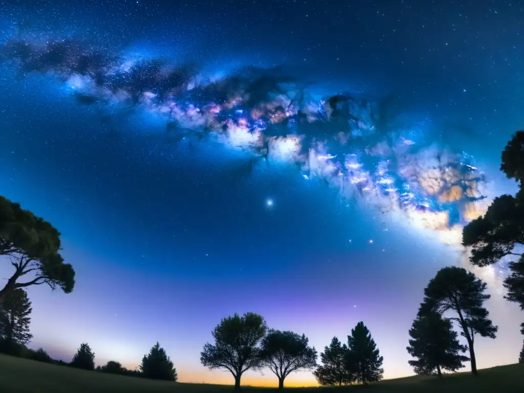 Una nostálgica vista de la Vía Láctea en una noche serena, sin contaminación lumínica, entre siluetas de árboles